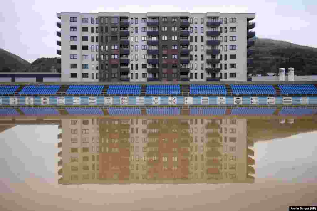 Apartment buildings are reflected by a flooded soccer field after heavy rain in the village of Kiseljak in Bosnia-Herzegovina.&nbsp;