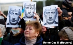 Плакаты с изображением президента России Владимира Путина во время митинга с требованием к России прекратить войну против Украины. Рим, 27 февраля 2022 года