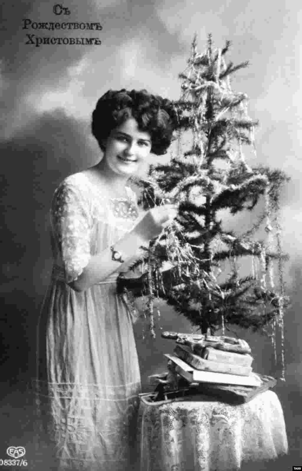 A 1912 Christmas postcard of a woman and her pint-sized tree. Christmas traditions such as the decorated tree were introduced to Russia from Europe around 200 years ago, and were gradually taken up by Russia's wealthy. But the lower classes were apparently less fond of the custom. Pravda, the Soviet propaganda mouthpiece, reported that each year workers' children "peered enviously through the window at the fir tree glittering with multicolored lights and the rich children who were merry around it." 