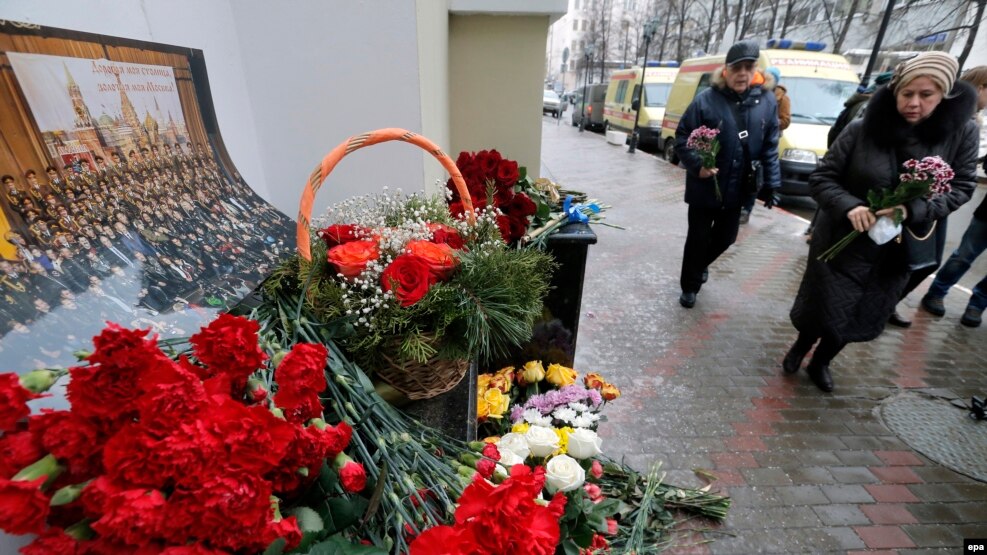 Mourners leave flowers at a small impromptu memorial outside the home stage of the Aleksandrov Ensemble in Moscow on December 25.