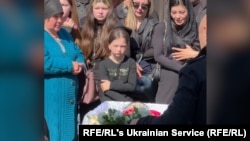 Mourners near Kyiv honor Anna Yefymenko, a young mother who was killed while protecting her four-year-old son on May 18.