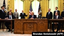 U.S. President Donald Trump (center), Kosovar Prime Minister Avdullah Hoti (right), and Serbian President Aleksandar Vucic (left) listen to U.S. Vice President Mike Pence during a signing ceremony for an economic normalization deal between the two Balkan countries in Washington on September 4. 