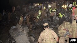 Pakistani soldiers search for victims from the wreckage of the crashed PIA passenger plane Flight PK661 at the site in the village of Saddha Batolni in the Abbottabad district of Khyber Pakhtunkhwa province on December 7.