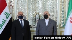 IRAN -- In this picture released by the Iranian Foreign Ministry, Foreign Minister Mohammad Javad Zarif, right, and his Iraqi counterpart Fuad Hussein talk while posing for media prior to their meeting in Tehran, Iran, Saturday, Sept. 26, 2020.