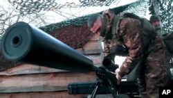 A Russian paratrooper prepares his sniper rifle at an undisclosed location in Ukraine on April 8. The Freedom House report singled out Russia and Azerbaijan for their "wars of aggression."