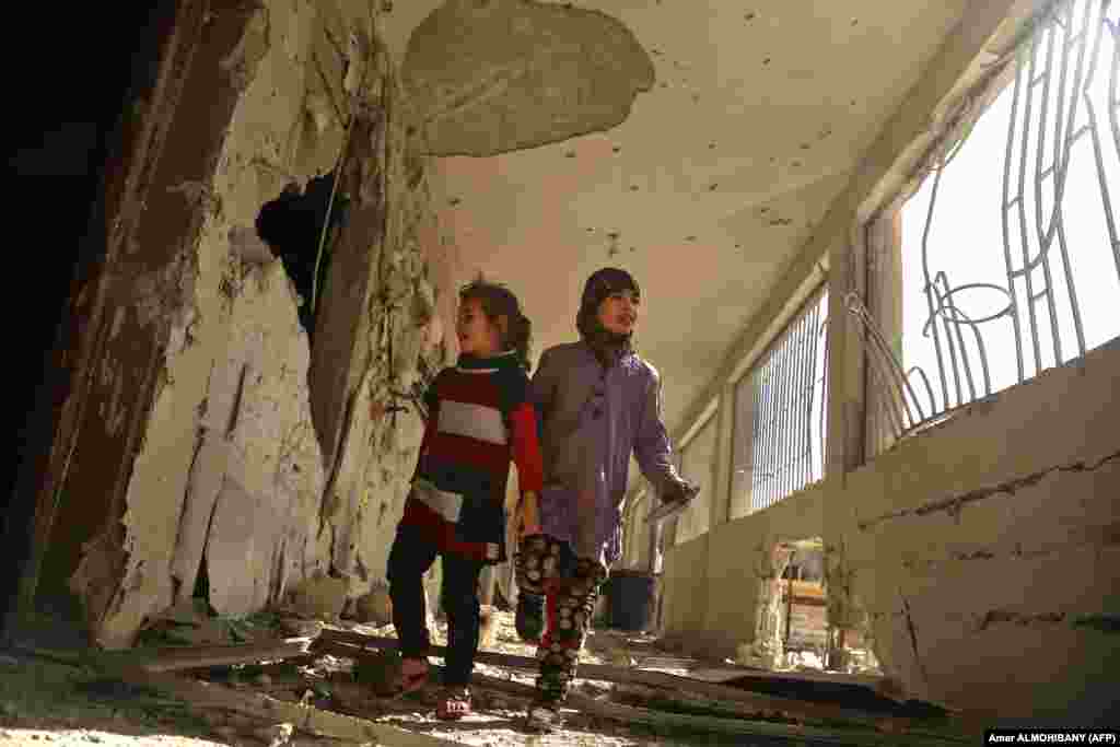 Syrian children tour their damaged school in the besieged rebel-held Eastern Ghouta town of Saqba, on the outskirts of the Syrian capital, Damascus, following air raids by government forces on the area the previous day. (AFP/Amer Almohibany)