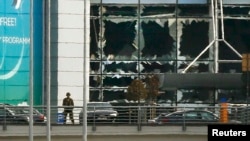 Солдат стоїть біля вибитих вибухом вікон аеропорту Брюсселя, 22 березня 2016 року
