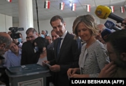 Bashar al-Assad dhe bashkëshortja e tij Asma duke votuar në Damask më 26 maj, 2021.