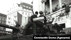 Doi militari citind presa liberă pe tancul care apăra de această dată vorbitorii din balconul Operei din Timișoara pe 27 decembrie 1989. Revoluția Română era victorioasă. Partidele istorice tocmai se reînregistraseră legal. Urmau primele alegeri libere în mai mult de patru decenii.