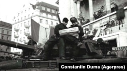 27 decembrie 1989, Timișoara – Revoluția Română. Doi soldați pe un tanc citesc primele ziare apărute după 22 decembrie în Piața Operei.