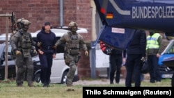 Policemen escort Serhii K. to a hearing with a prosecutor in Karlsruhe, Germany, on November 28, 2025.