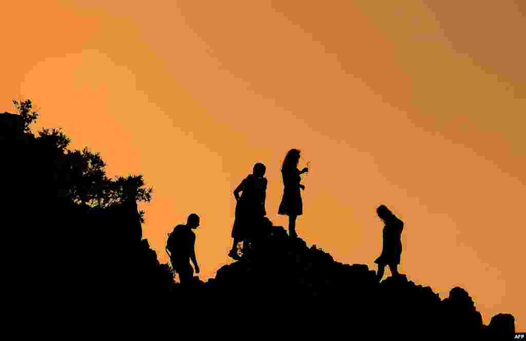 People gather for sunrise at a rocky crest filled with astronomical markers at the megalithic observatory of Kokino during the summer solstice. The ancient astronomic observatory, located about 100 kilometers northeast of Skopje, Macedonia, dates back more than 4,000 years ago. (AFP/Robert Atanasovski)