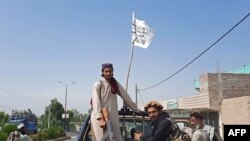 Бойцы талибов ведут транспортное средство афганской национальной армии (ANA) по улицам провинции Лагман, 15 августа 2021 года. 