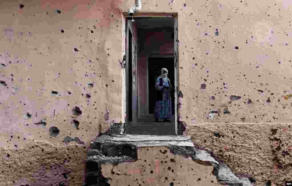 A woman walks inside a bullet-riddled house in the Sur district of the Kurdish dominated southeastern city of Diyarbakir, Turkey, on October 30, 2015. Turkish security forces have fought frequent battles with Kurdish militants in the area. (epa/Sedat Suna)