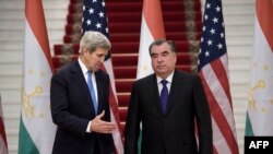 Tajikistan -- US Secretary of State John Kerry extends his hand to Tajik President Emomali Rahmon (R) upon his arrival for a meeting at the Palace of Nations in Dushanbe, November 3, 2015