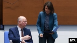 Елисавета Белобрадова от ПП-ДБ връчва на премиера Росен Желязков от ГЕРБ папка с оставка по време на заседанието на парламента в петък, 5 декември 2025 г.