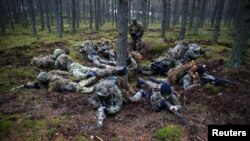Participants secure a position during a territorial defense training exercise organized by the paramilitary group SJS Strzelec (Shooters Association) in the forest near Minsk Mazowiecki in eastern Poland last year.