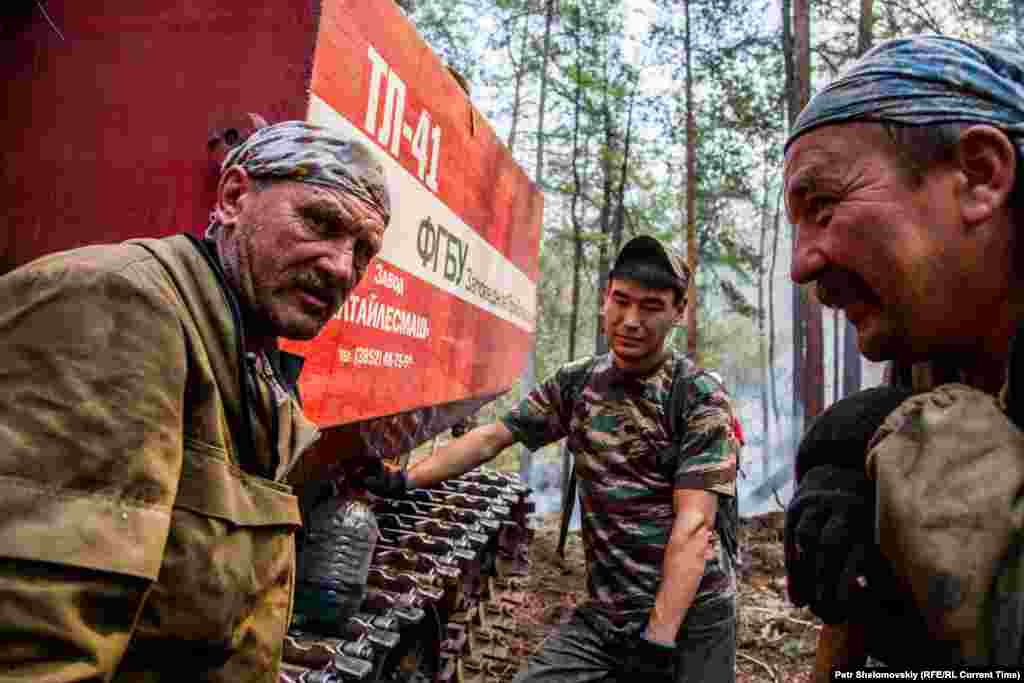 Forest rangers take a break by their truck amid the heat and hard work.