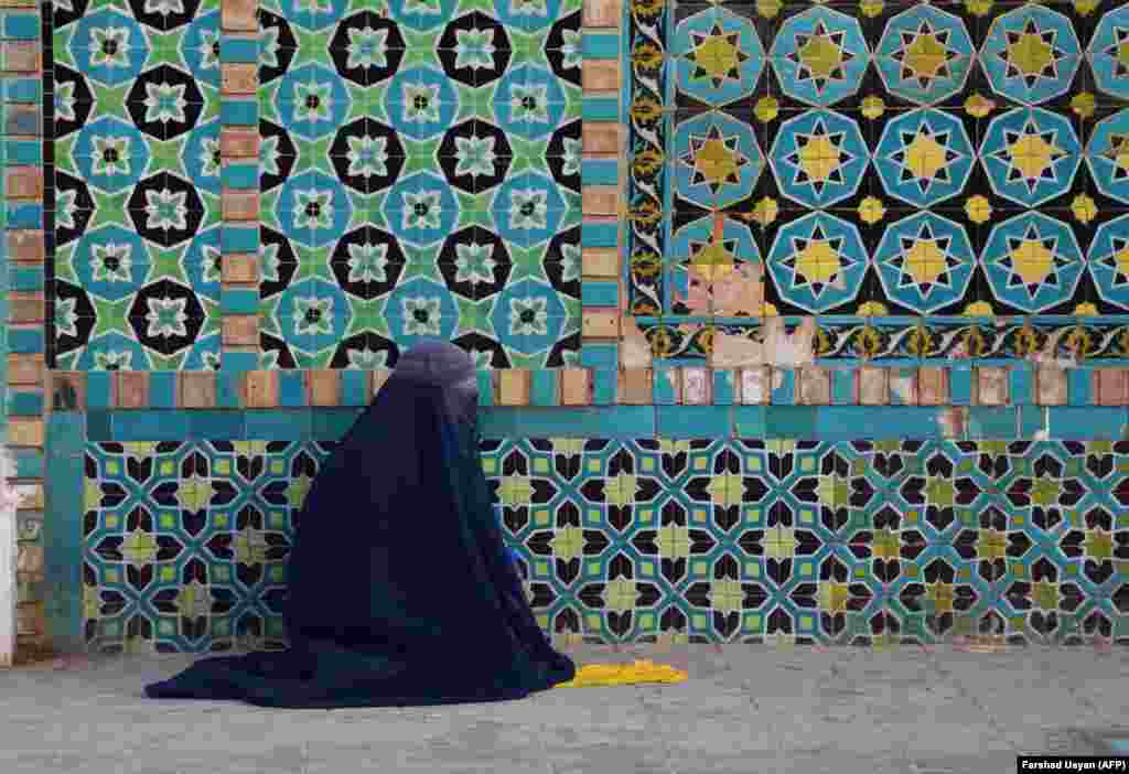 A burqa-clad Afghan woman sits in the courtyard of the Hazrat-e Ali shrine, or &quot;Blue Mosque,&quot; in&nbsp; Mazar-e Sharif during the holy month of Ramadan. (AFP/Farshad Usyan)