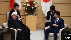 Iranian President Hassan Rouhani (L) and Japanese Prime Minister Shinzo Abe (R) attend a meeting at the prime minister's office in Tokyo on December 20, 2019. 