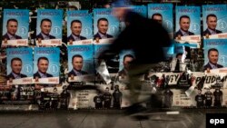 A man rides his bicycle past election posters of former Prime Minister and VMRO-DPMNE leader Nikola Gruevski in Skopje.