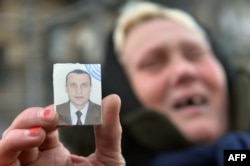 Женщина держит фотографию, по ее словам, пропавшего сына. Киев, 31 января 2014 года.