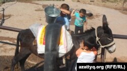 Дети села Амангельды Казыгуртского района Южно-Казахтанской области пополняют запасы воды, 21 сентября 2014 года. 