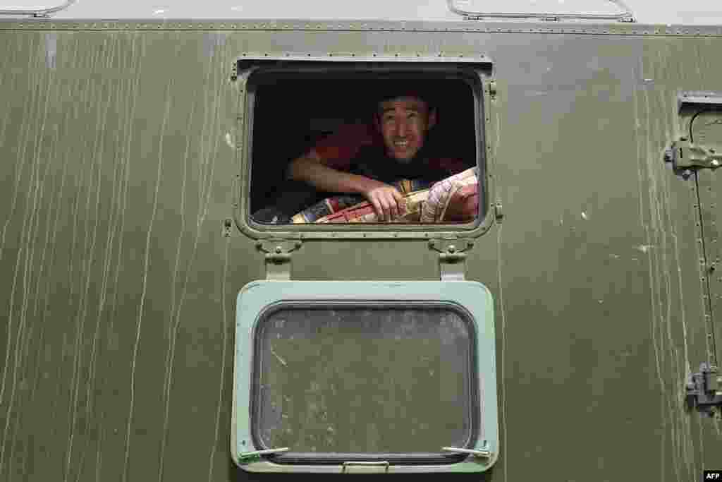 A Kyrgyz emergency worker unloads mattresses for people evacuated after violent clashes along the Kyrgyz-Tajik border. (AFP)