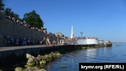 Люди на набережной Корнилова в Севастополе наблюдают за репетицией военного парада, архивное фото