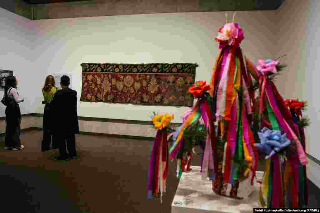 На передньому плані – традиційне українське весільне дерево (реконструкція). На задньому – килим євреїв Київського Полісся