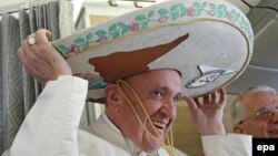 Папа Францішак прымярае самбрэра, якое атрымаў ад мэксіканскага журналіста ў аэрапорце Гаваны