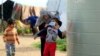 A Syrian refugee woman puts a face mask on a boy as a precaution against the spread of coronavirus, in al-Wazzani area, in southern Lebanon, March 14, 2020