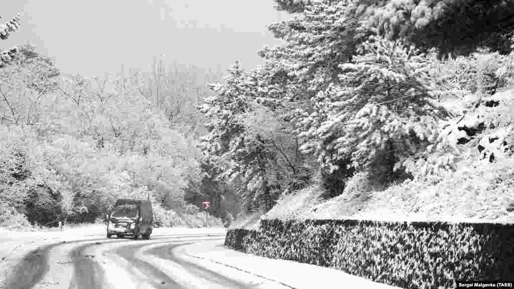 По занесенной снегом дороге неподалеку от Гаспры пробирается автомобиль