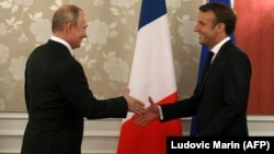 French President Emmanuel Macron (rights) meets with Russian President Vladimir Putin in Osaka in June.