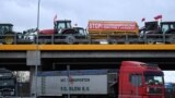 „Opriți intrarea necontrolată de mărfuri din Ucraina” scrie pe remorca unui tractor care participă la blocarea autostrăzii Varșovia - Lublin, în apropiere de localitatea Ryki, Polonia, 20 februarie 2024.