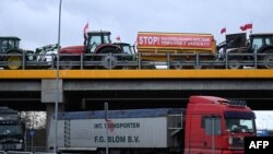 „Opriți intrarea necontrolată de mărfuri din Ucraina” scrie pe remorca unui tractor care participă la blocarea autostrăzii Varșovia - Lublin, în apropiere de localitatea Ryki, Polonia, 20 februarie 2024.