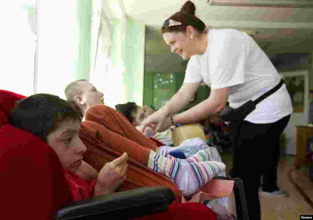 Volunteer Emma Gaughan plays with a child. The volunteers are involved in training local care workers, as well as helping patients with daily activities.