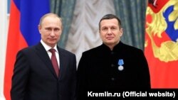 Vladimir Putin (solda) teleaparıcı Vladimir Solovyovu Kremldə ordenlə təltif ediləndən sonra