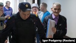  Yury Dmitriyev (djathtas) në përcjellje të policit derisa shkonte në gjykatë gjatë vitit 2017