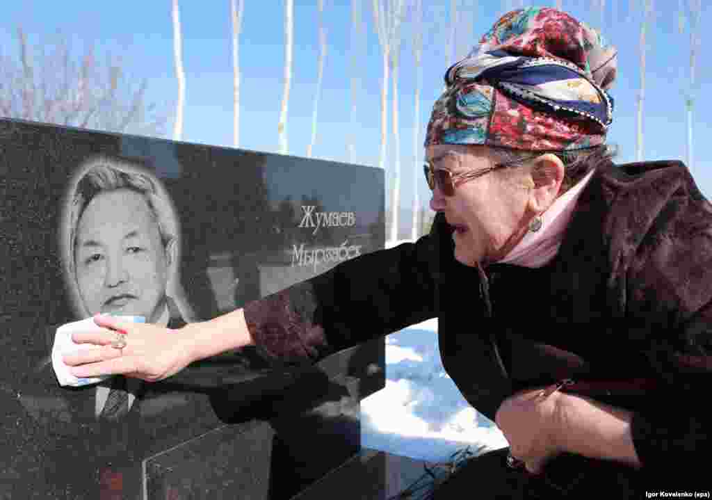 A Kyrgyz woman polishes a commemorative plate for a relative at the Ata-Beyit memorial complex for the victims of a 2010 violent revolt against the government, some 20 kilometers outside of Bishkek, on April 7. (epa/Igor Kovalenko)