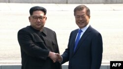 Солтүстік Корея басшысы Ким Чен Ын (сол жақта) Оңтүстік Корея президенті Мун Чжэ Инмен қол алысып тұр. 27 сәуір 2018 жыл. 