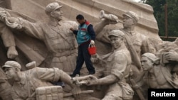 Тяньаньмэнь алаңындағы ескерткішті тазартып жүрген жұмысшы. Пекин, 1 қараша 2013 жыл.