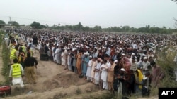 Pakistani relatives and residents offer prayers for those killed after an oil tanker exploded, during mass funerals for the victims on June 27. 