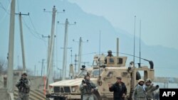 U.S. soldiers stand guard near the site of the suicide attack near Camp Phoenix on January 26.