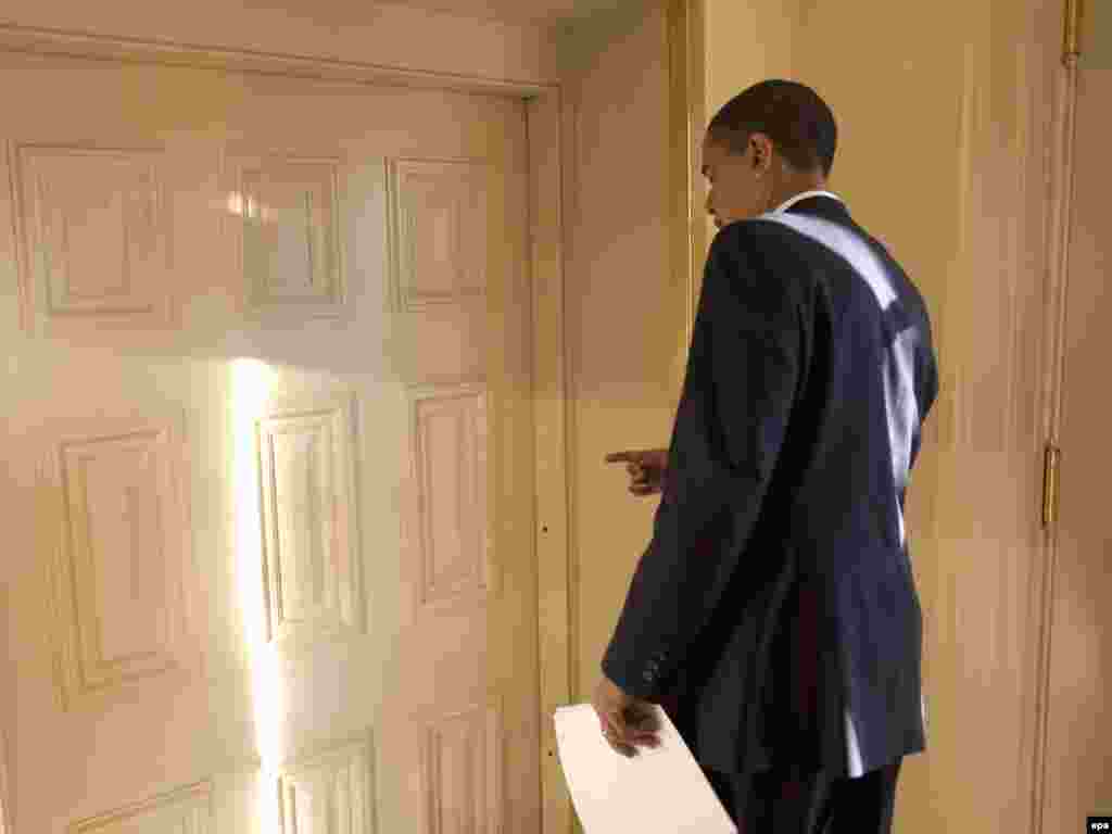 Presidenti Barack Obama duke hyrë në zyren e tij më 21 janar, 2009.