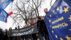 Удзельнікі пратэставай акцыі на Дзень Волі ў Менску трымаюць сьцяг, які заклікае да эўраінтэграцыі Беларусі і Ўкраіны. 2014 год