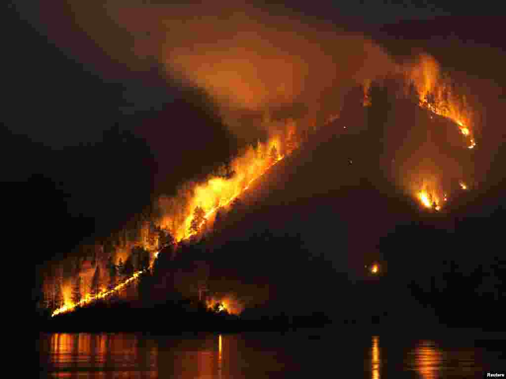 Dry grass, bushes and trees burn on the bank of the Yenisei River in the Taiga district, near Russia's Siberian city of Krasnoyarsk, on April 21, 2011. Russia faces a danger of forest fires in Siberia and its Far East, following blazes that ravaged thousands of hectares of land last year, Prime Minister Vladimir Putin said.Photo by Ilya Naymushin for Reuters