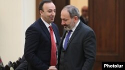 Armenia -- Prime Minister Nikol Pashinian (R) and Constitutional Court Chairman Hrayr Tovmasian shake hands ahead of a 2018 meeting in Yerevan.