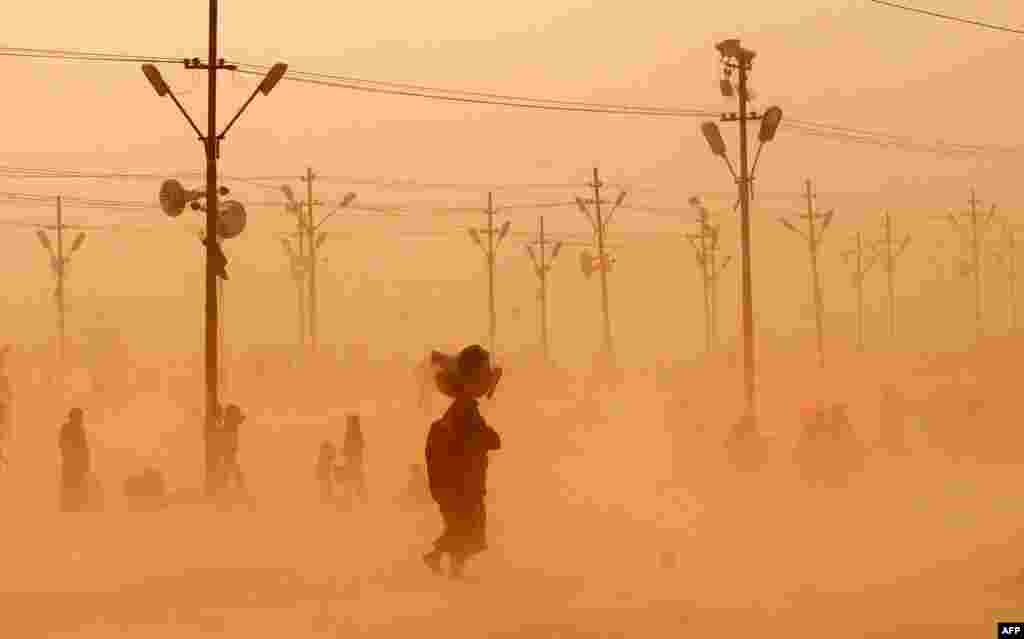 Hindu devotees walk through a dust storm after taking a holy dip at the confluence of the rivers Ganges, Yamuna, and Saraswati during the Maha Kumbh festival in Allahabad, India. Up to 100 million worshippers gather over 55 days to take a ritual bath in the holy waters, believed to cleanse sins and bestow blessings. (AFP/Sanjay Kanojia)