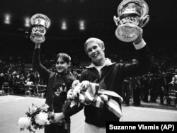 Nadia Comaneci and U.S. gymnast Bart Conner hold trophies aloft after winning events at a gymnastics competition in 1976. The two Olympic gold-medal winners would wed in 1996, years after Conner helped extricate Comaneci from a relationship with Constantin Panait, a Romanian emigre who the gymnast said had abused her after she escaped to the West.